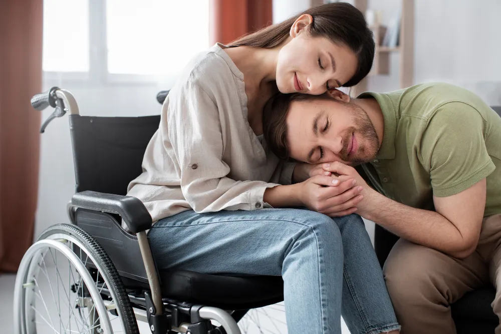 Hombre ayudando a su pareja con diversidad funcional en casa.